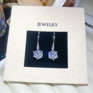 Macro detail of elegant round cubic zirconia earrings with micro-pave silver hooks and stones.