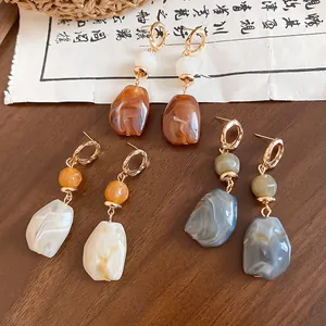 Elegant Maillard style irregular resin earrings in brown, grey and beige tones on wood