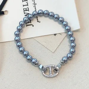 Detailansicht eines grauen Perlenarmbandes mit Zirkonia-besetztem Ankerverschluss.