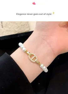 Nahaufnahme eines eleganten Perlenarmbands mit goldener, zirkonbesetzter Schließe im Detail