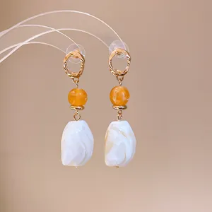 Detailed view of Maillard style irregular geometric earrings featuring marbled white resin