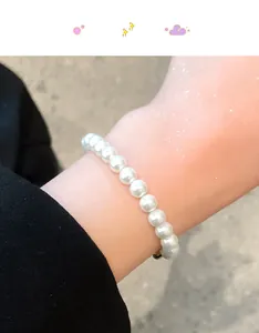 Nahaufnahme eines eleganten weißen Perlenarmbands mit sicherem Verschluss am Handgelenk