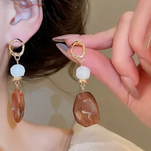 Detail view of Maillard resin irregular geometric drop earrings with marbled brown finish
