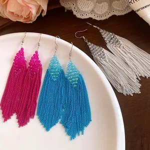 Boucles d'oreilles à pompons en perles acryliques rose, bleu et argent sur plat
