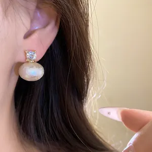 Close-up detail of a vintage French style cotton pearl earring with a sparkling zircon
