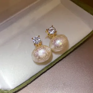 Macro view of vintage French style stud earrings with matte cotton pearls and zircon
