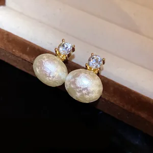 Detailed macro view of French retro style cotton pearl stud earrings featuring shiny zircon accents