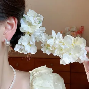 Elegant white fabric flower hair clip with pearl accents for women side styling.