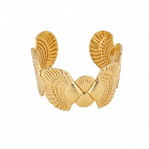 Elegant gold open cuff bracelet featuring an intricate wing texture for resort style fashion