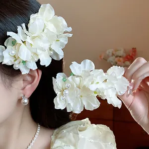 Close-up of ethereal fabric flower hair clip with elegant pearls on an Asian model