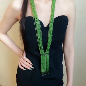 Handgefertigte lange mehrreihige grüne Perlenkette an einem Model im schwarzen Kleid