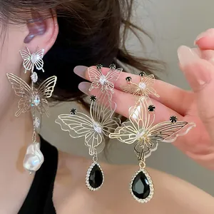Close-up of French vintage openwork butterfly earrings with rhinestones and black drop gems