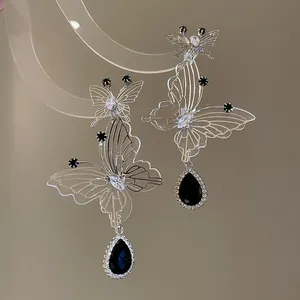 Detailed close-up of elegant silver hollow butterfly earrings with black teardrop stones
