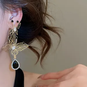 Elegant gold-tone hollow butterfly drop earrings with black teardrop gemstone and rhinestones