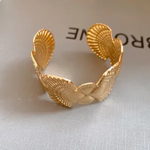 Detailed macro shot of a gold sea shell textured open cuff bracelet for beach holidays