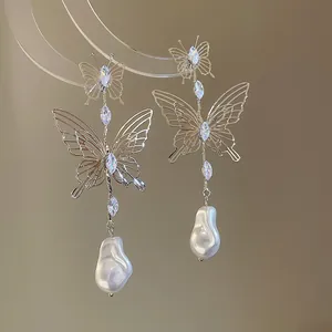 Detail view of French hollow butterfly earrings with marquise stones and drop pearls