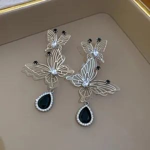 Close-up of French vintage hollow butterfly earrings with black teardrop pendant