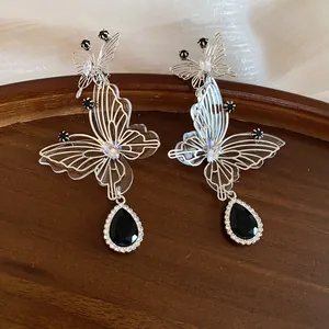 Detailed view of hollow butterfly earrings with black teardrop crystal pendant