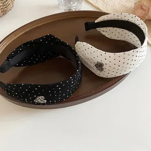 Set of black and white polka dot wide headbands with sparkly heart detail on a tray