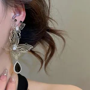 Close-up of French vintage style hollow butterfly earrings with black waterdrop pendant.