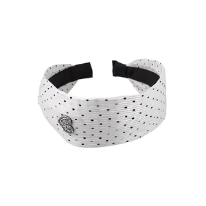 Wide white pleated headband featuring black polka dots and a rhinestone heart accent
