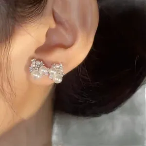 Elegant zircon pearl bow stud earrings with silver needles for a niche luxury look.