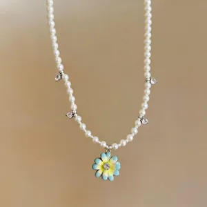 Elegant pearl necklace with zircon heart charms and blue enameled flower pendant
