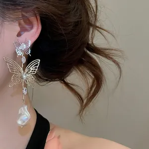 Detailed view of French-style hollow butterfly earrings with elegant waterdrop pearls.