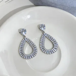 Detailed close-up showing intricate hollow teardrop design of silver zircon earrings.