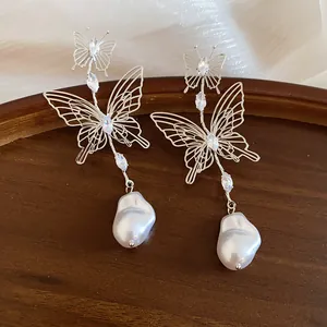 Detailed view of French vintage hollow butterfly earrings with marquise rhinestones and pearls.