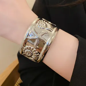 Close-up of silver starfish cuff bracelet worn on wrist for coastal style