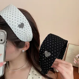 Detail of wide pleated polka dot headband with rhinestone heart decoration.