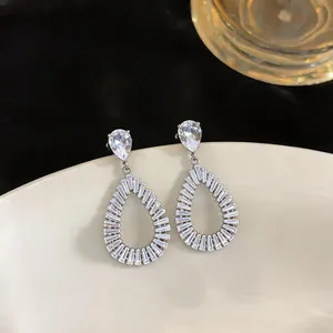 Close-up of elegant hollow teardrop earrings with sparkling zircon crystals
