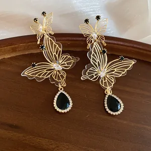 Detail shot of vintage hollow butterfly earrings with black teardrop crystal pendant