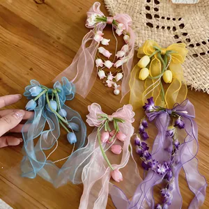 Primo piano di eleganti fermagli per capelli a fiocco in chiffon con tulipani e mughetti