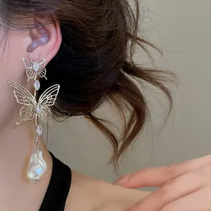 Detailed macro shot of French style hollow butterfly earring with teardrop pearl drop