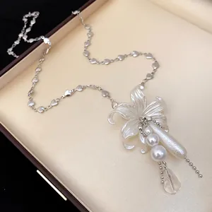 Collier pendentif fleur élégant avec perles et chaîne cœur dans une boîte de luxe.