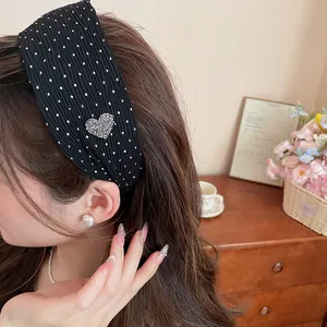 Detailed view of black polka dot wide headband with a sparkling rhinestone heart