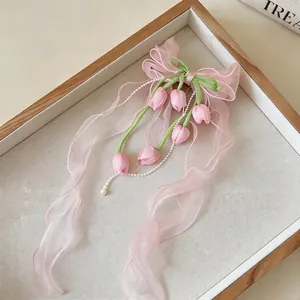Vista dettagliata di un fermaglio per capelli in chiffon rosa con pendenti tulipano.