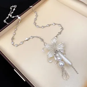 Vue détaillée du pendentif fleur blanche et perle sur une chaîne à maillons cœur