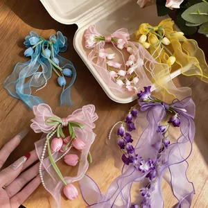 Dettaglio di fermagli per capelli in chiffon con eleganti ciondoli a forma di tulipano.