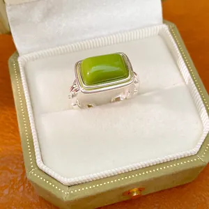 Close-up of a stylish green resin square open ring in a silver setting box