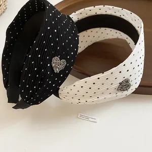 Close-up detail of black and white polka dot headbands with a rhinestone heart ornament