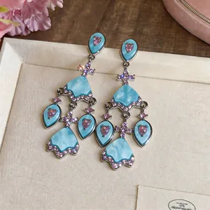 Vintage-Kronleuchter-Ohrringe mit blauen Steinen und rosa Herz-Zirkonen im Detail