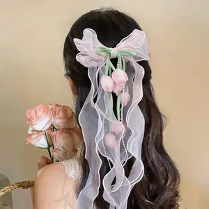 Vista dettagliata di un elegante fermaglio per capelli in chiffon rosa con tulipani