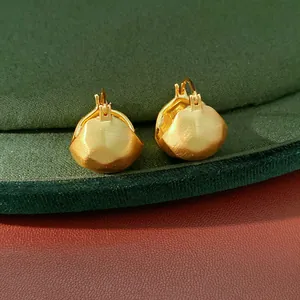 Detailed view of brushed gold geometric semi-circular ear buckles with minimalist design