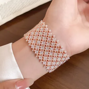 Nahaufnahme eines eleganten rotgoldenen und weißen Magnetarmbands mit Perlen am Handgelenk