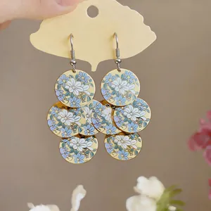 Eleganti orecchini pendenti rotondi con stampa floreale blu e bianca in smalto lucido.