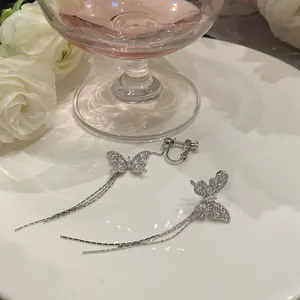 Close-up detail of sparkling crystal butterfly earrings with long elegant silver tassels