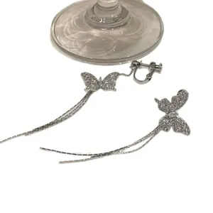 Asymmetrical butterfly tassel earrings with sparkling cubic zirconia crystals.